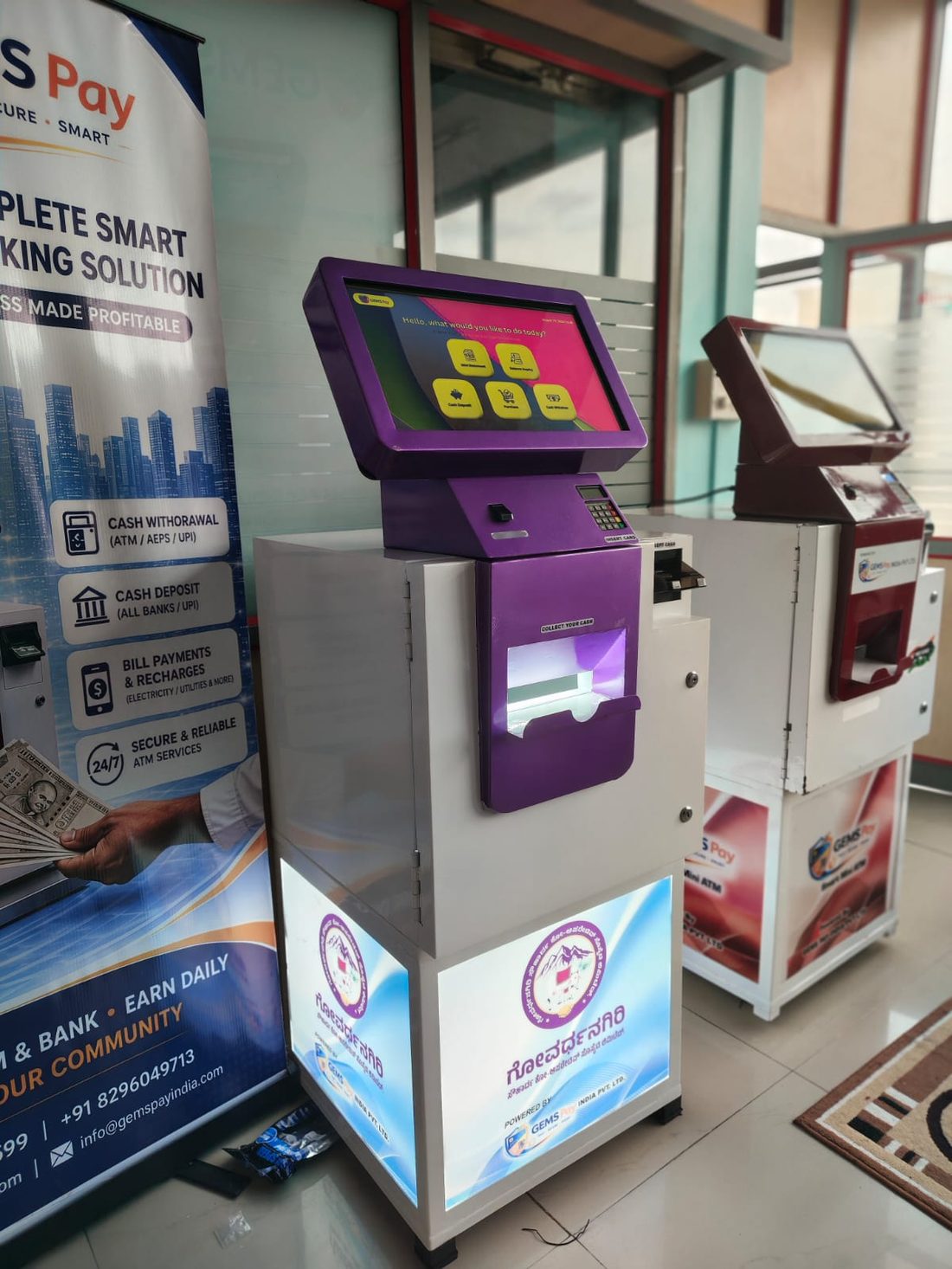 Purple-livery GEMS Pay kiosk beside a standard unit
